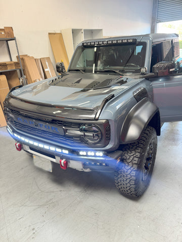 ford bronco with bright white lights, roof bar, bumper light bar, fog lights and ditch lights