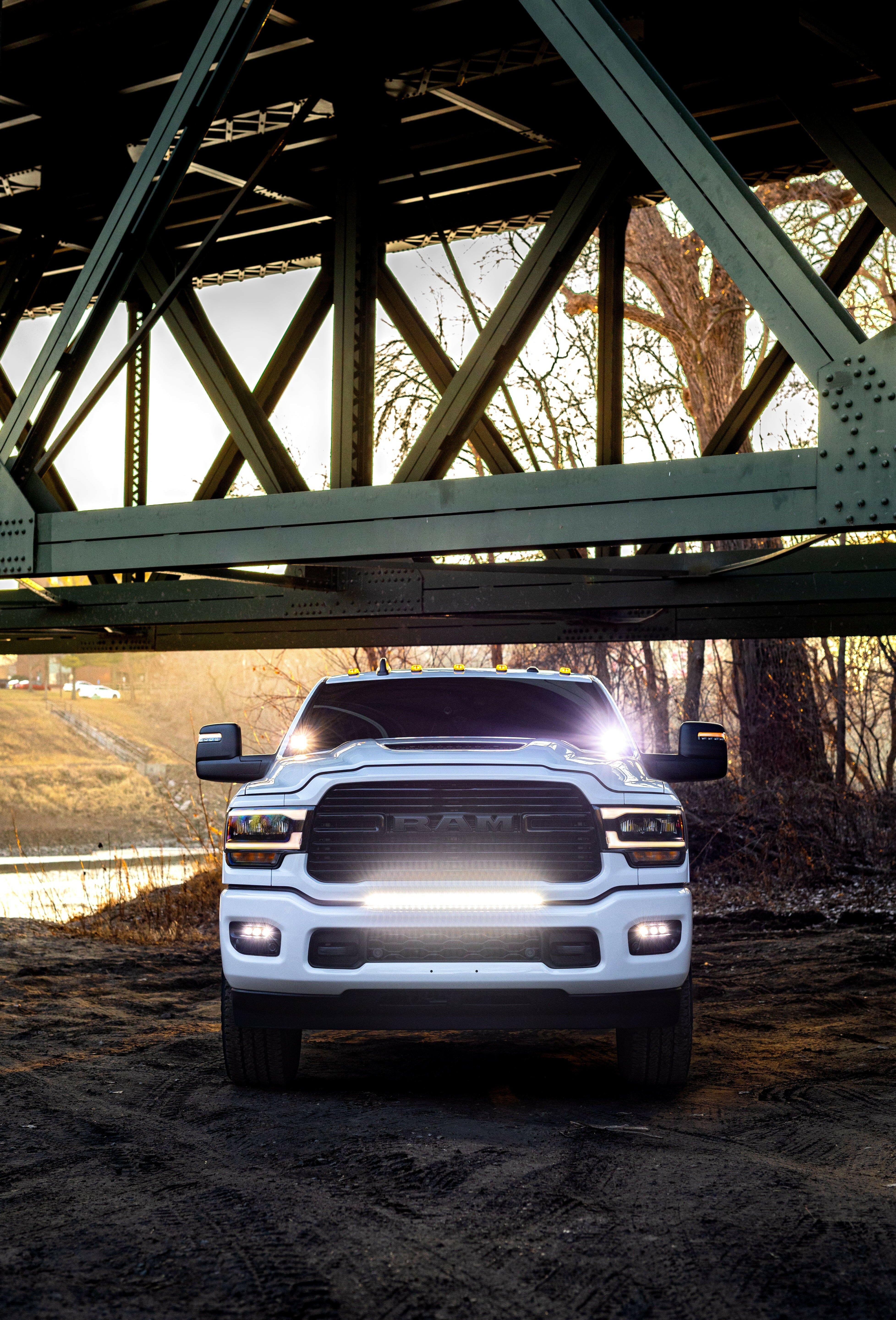 2025+ RAM 2500 3500 Ditch Lights dual-color LED ditch lights on white RAM truck under bridge at sunset