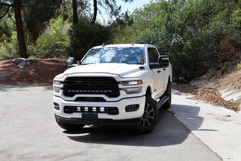 2025+ RAM 2500 Light kit lower grille pods installed on white RAM 2500 truck front view on road