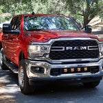 RAM 2500 lightbar Bumper Light kit installed in lower grille on red 2019-2024 RAM 2500 truck front view on wooded road