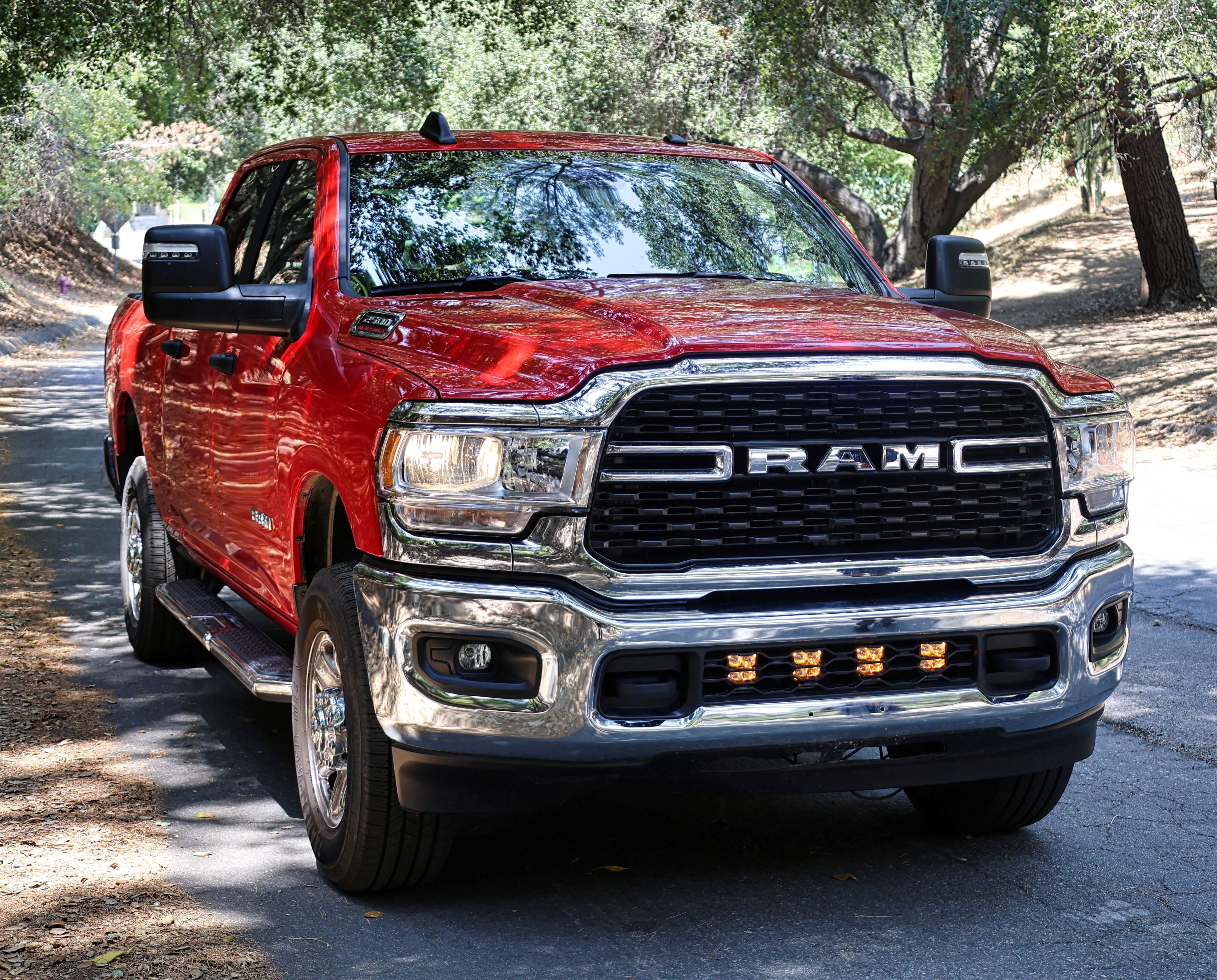 RAM 2500 lightbar Bumper Light kit installed in lower grille on red 2019-2024 RAM 2500 truck front view on wooded road