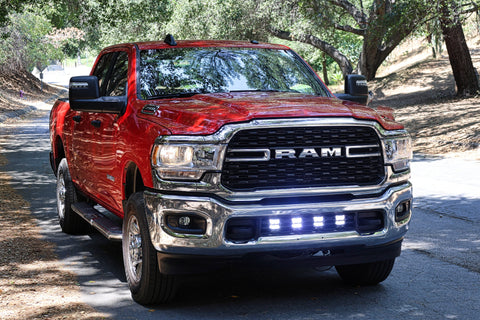 RAM 2500 lightbar Bumper Light kit installed on red RAM 2500 lower grille light pods 2019-2024 on forest road