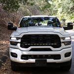 2025+ RAM 2500 & 3500 Ditch Lights installed on white RAM HD truck front view on wooded road