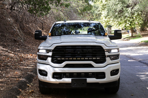 2025+ RAM 2500 & 3500 Ditch Lights installed on white RAM HD truck front view on wooded road