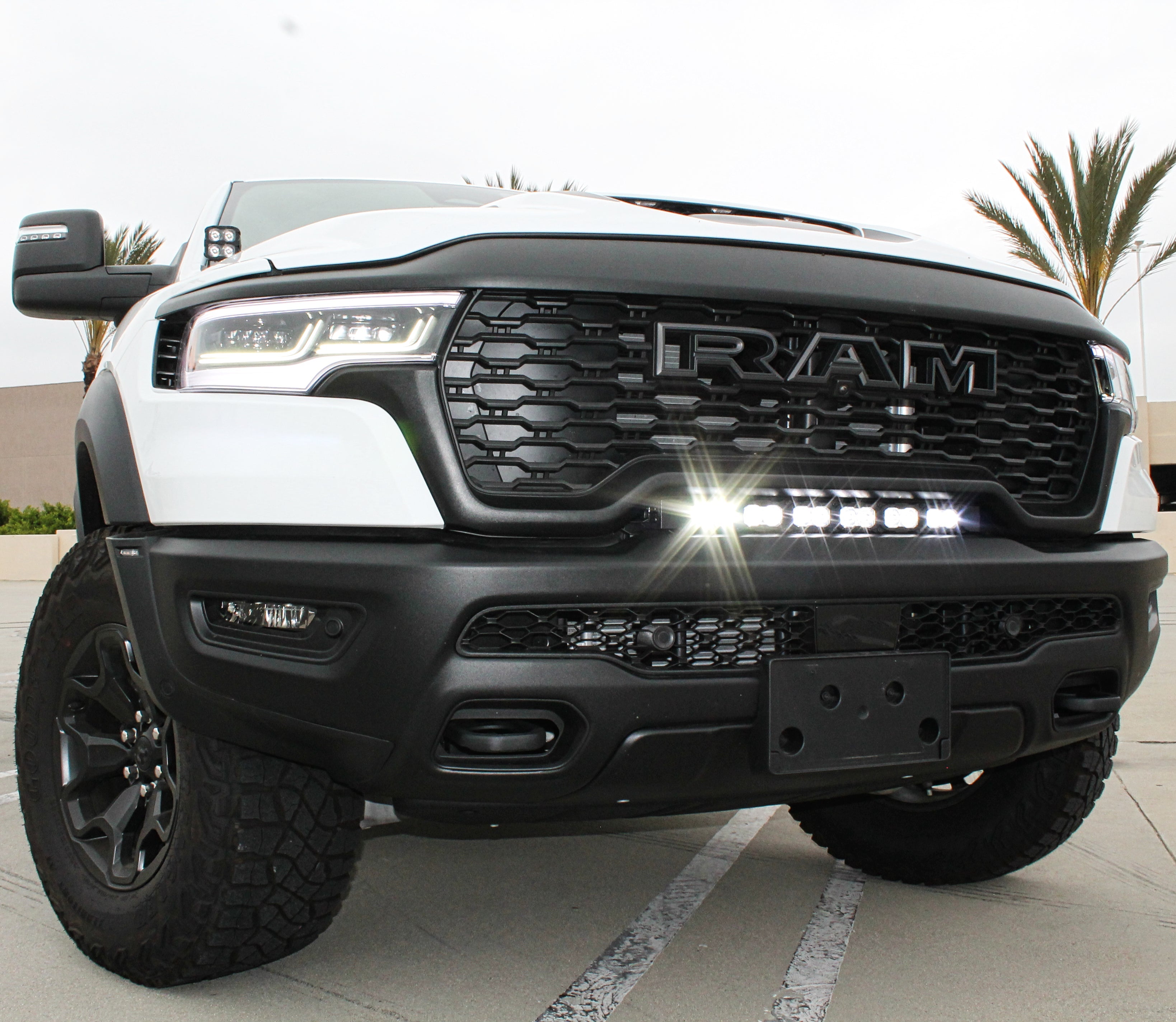 RAM RHO light bar installed on 2025 RAM 1500 RHO front grille, curved 23in PRO LED light bar between grille and bumper