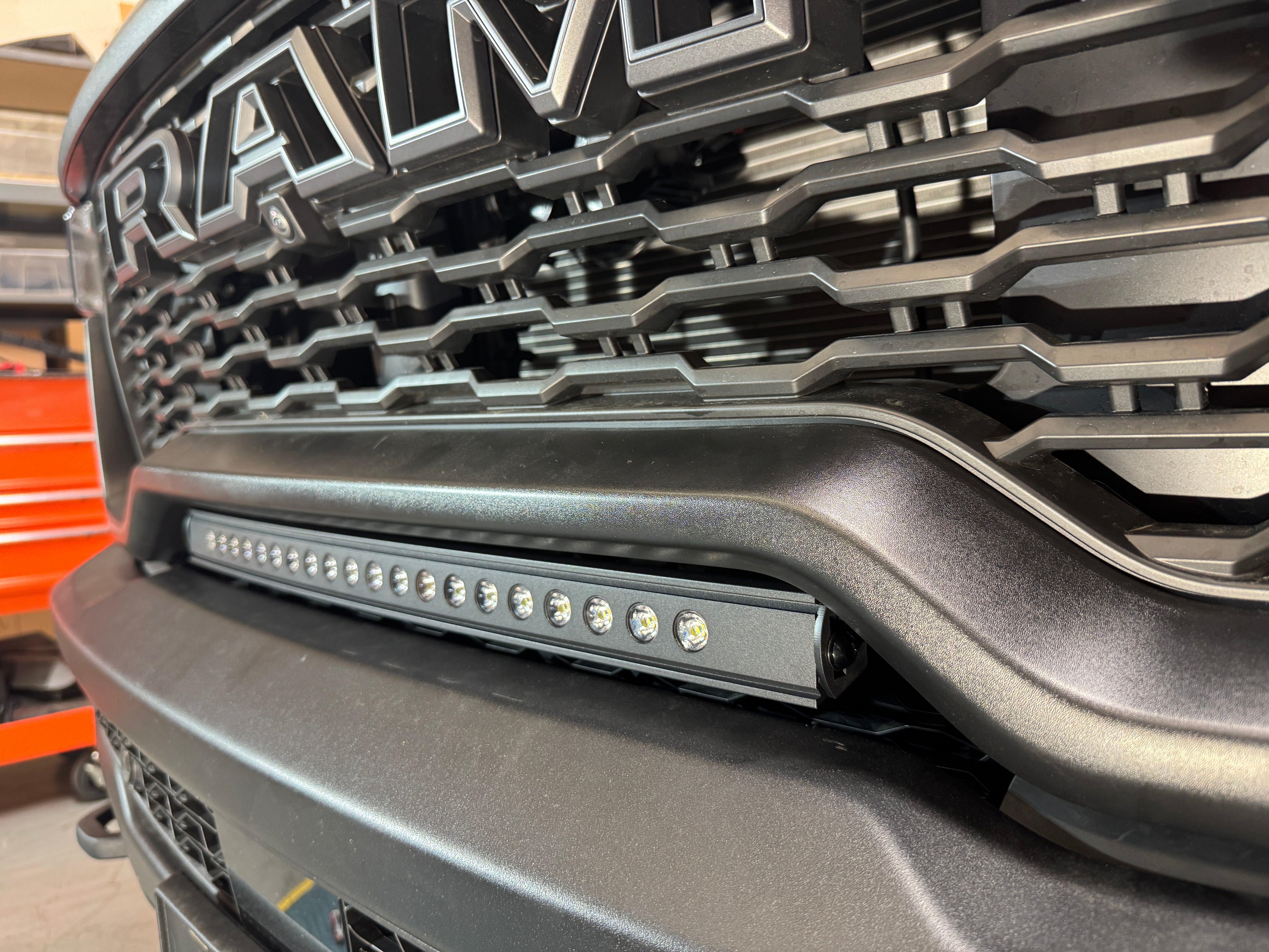 RAM RHO lightbar on 2025+ RAM 1500 Rebel with curved slim design, mounts between grille and bumper, powder-coated black bracket, 23in, RAM RHO lightbar
