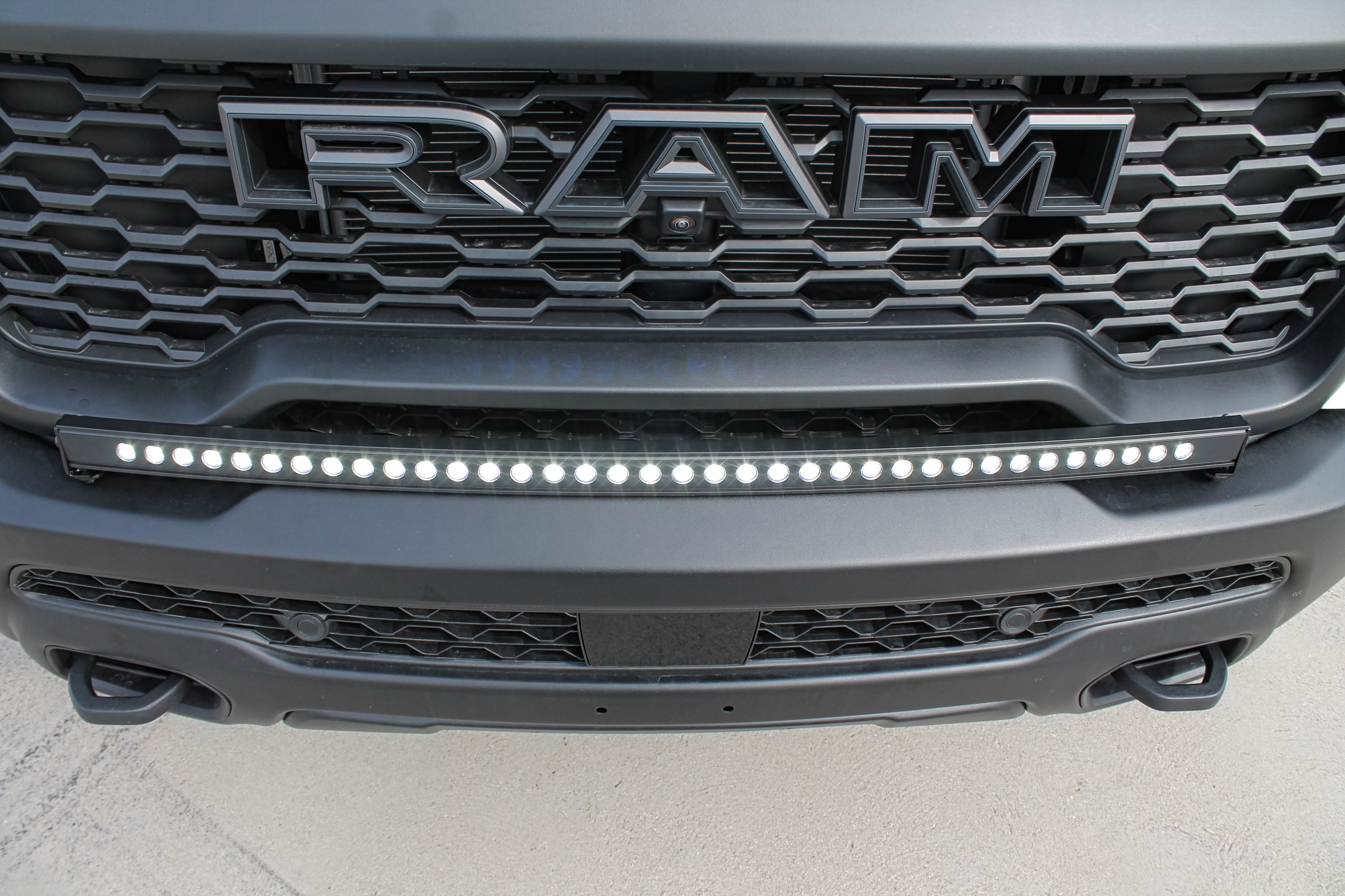 RAM RHO Lightbar on RAM RHO 2025+ 1500 bumper; curved slim LED lightbar with black powder-coated bracket, no grille cutting