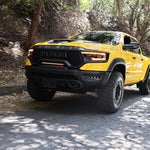 RAM TRX Light bar slim 23in installed in grille opening on yellow 2021-2024 RAM 1500 TRX driving on shaded road