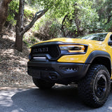 RAM TRX Light bar slim 23in installed on yellow 2021-2024 RAM 1500 TRX between grille and bumper on forest road