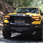 RAM TRX Lightbar 23in PRO installed on yellow 2021-2024 RAM 1500 TRX front grille and bumper opening on forest road