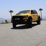Yellow RAM truck front view in parking lot showcasing RAM TRX Lightbar 23in PRO between grille and bumper