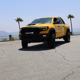 Yellow RAM truck front view in parking lot showcasing RAM TRX Lightbar 23in PRO between grille and bumper