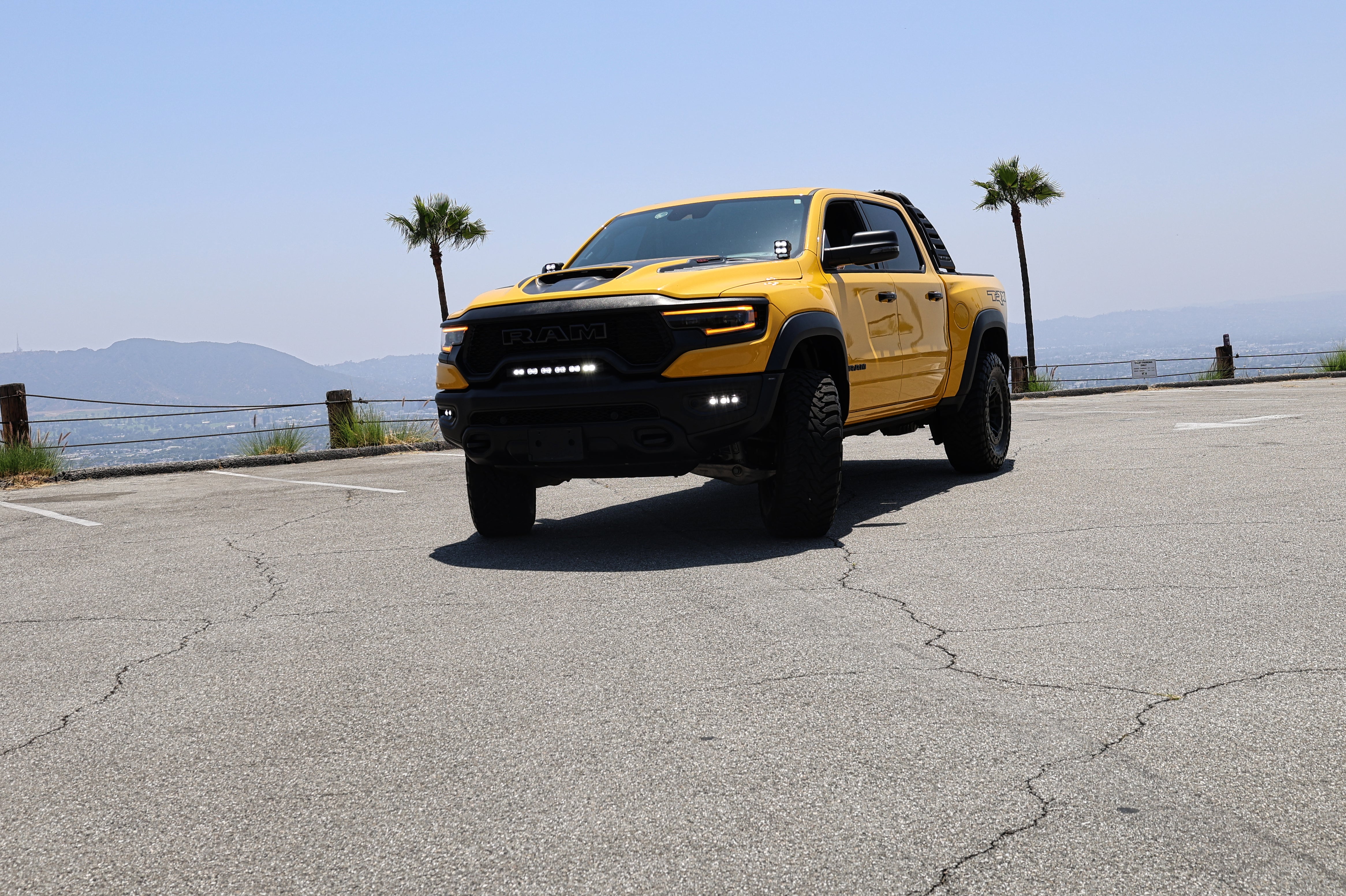 Yellow RAM truck front view in parking lot showcasing RAM TRX Lightbar 23in PRO between grille and bumper