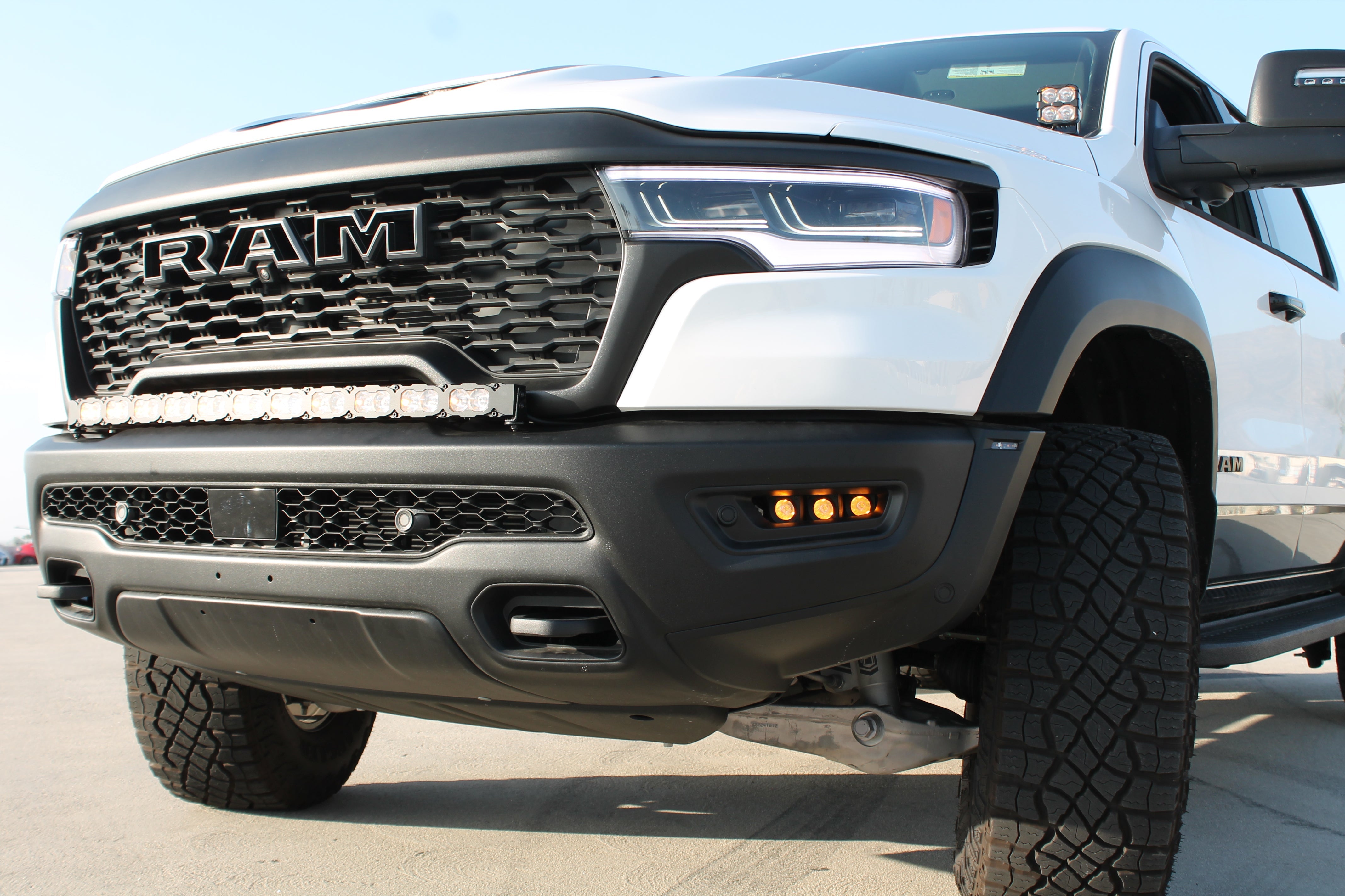 RAM RHO FOG light kit on 2025+ RAM 1500 - bolt-on factory openings, black powder-coated bracket visible with LED fog lights