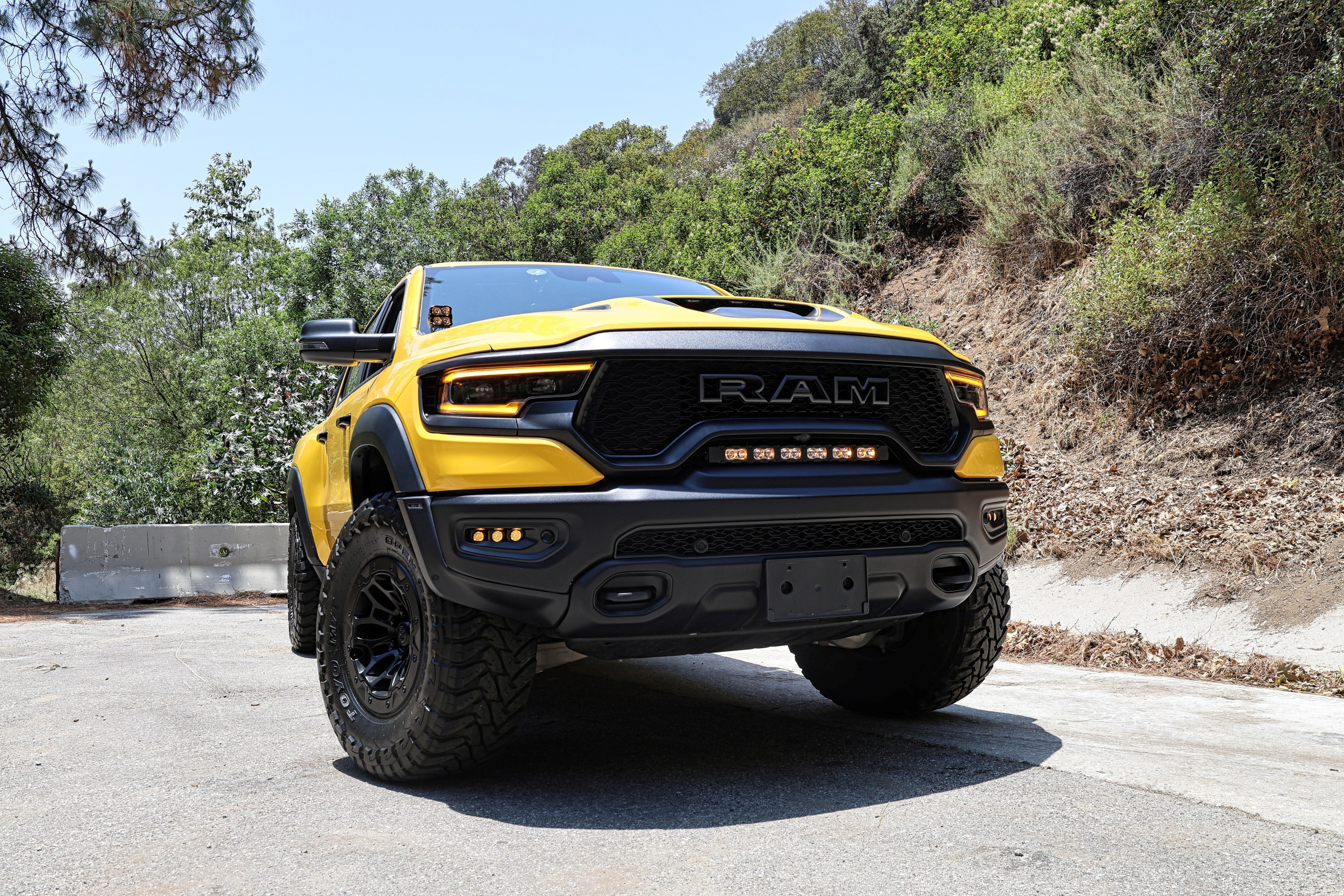 RAM TRX Lightbar 23in PRO on yellow RAM 1500 TRX in factory grille opening, off-road LED curved light bar front view