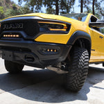 RAM TRX Lightbar 23in PRO installed on yellow RAM 1500 TRX 2021-2024 between grille and bumper on mountain road