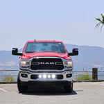 RAM 2500 lightbar Bumper Light kit installed on red 2019-2024 RAM 2500 lower grille LED light pods on in daylight parking lot