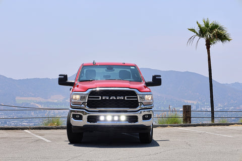 RAM 2500 lightbar Bumper Light kit installed on red 2019-2024 RAM 2500 lower grille LED light pods on in daylight parking lot
