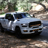 2025+ RAM 2500 Light kit lower grille pods installed on white RAM 2500 truck driving on wooded road