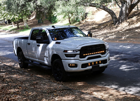 2025+ RAM 2500 Light kit lower grille pods installed on white RAM 2500 truck driving on wooded road
