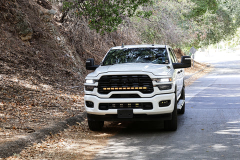 2025+ RAM 2500 Light kit lower grille pods installed on white RAM 2500 truck driving on wooded road