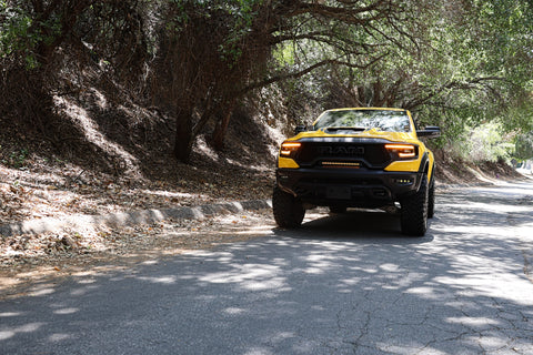 Yellow RAM TRX Light bar installed in grille opening, 23in slim curved LED light bar on 2021-2024 RAM 1500 TRX driving in sunlight