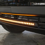 close up view black tesla cybertruck with amber curved LED light bar in the bumper