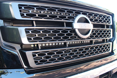 black nissan titan with off road led light bars behind the grille up close view