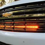 white 2021 2022 2023 2024 Chevrolet Suburban with one led amber light bars behind the grille for off roading