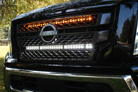black nissan titan with off road led light bars behind the grille white and amber  up close view