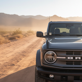 Ford Bronco Ditch Lights on rugged off-road truck in desert landscape with amber DRL backglow and white LED main lights