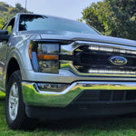 gray 2021 2022 2023 ford f150 with 2 white 30in light bars behind the grille 