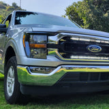 gray 2021 2022 2023 ford f150 with 2 white 30in light bars behind the grille 