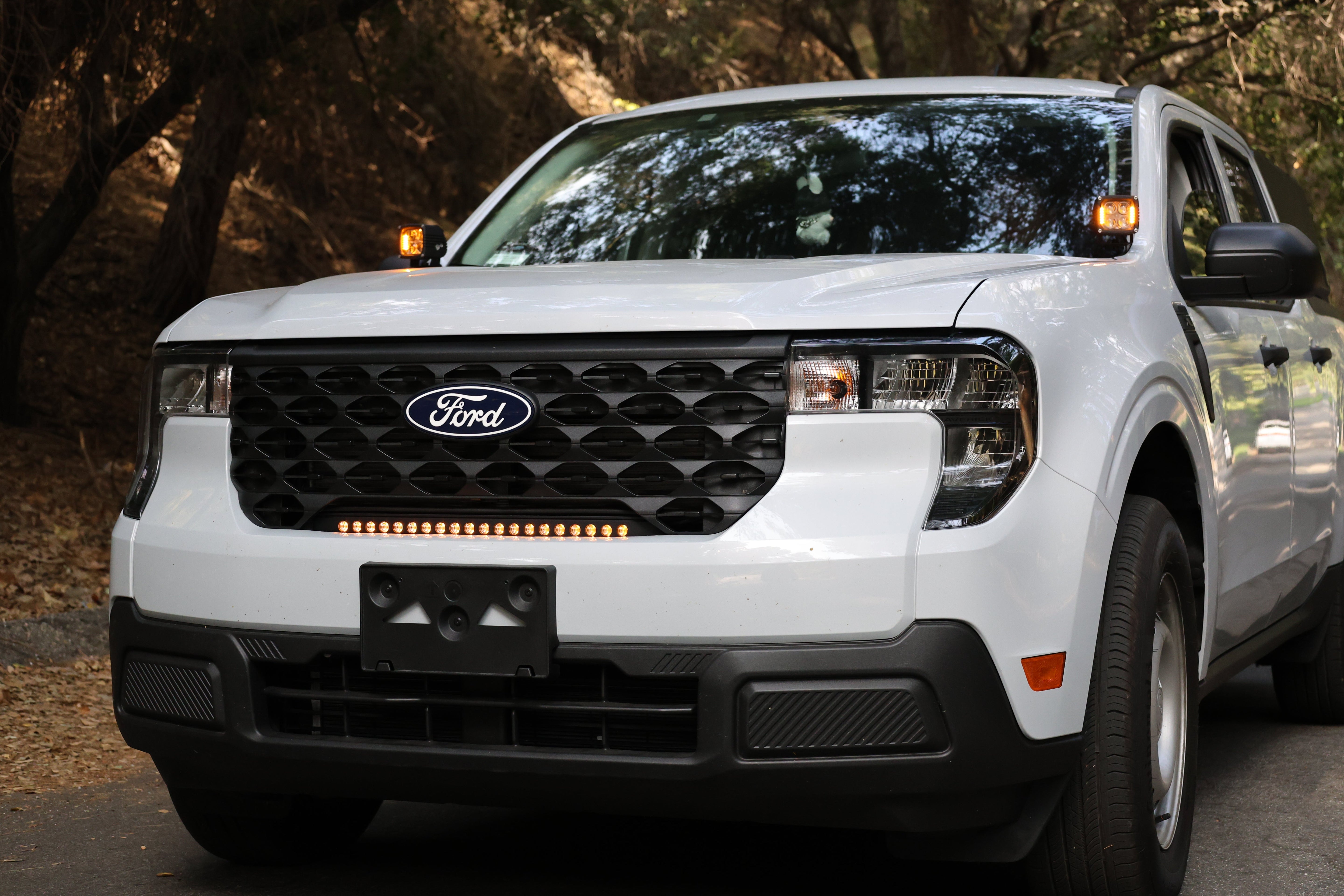 Ford Maverick Ditch Lights 2025+ dual color amber DRL installed on white Ford Maverick front view in wooded setting