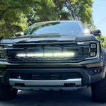 Front view of a black 2024 Ford Ranger Raptor showcasing hood mount LED lights on a sunny day.