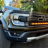 2024 Ford Ranger Raptor with hood mount LED lights showcasing amber DRL backglow in outdoor setting.