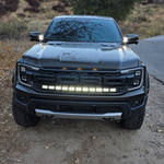 Ranger Raptor ditch lights dual color LED bar on front of 2024+ Ford Ranger Raptor in rugged off-road setting