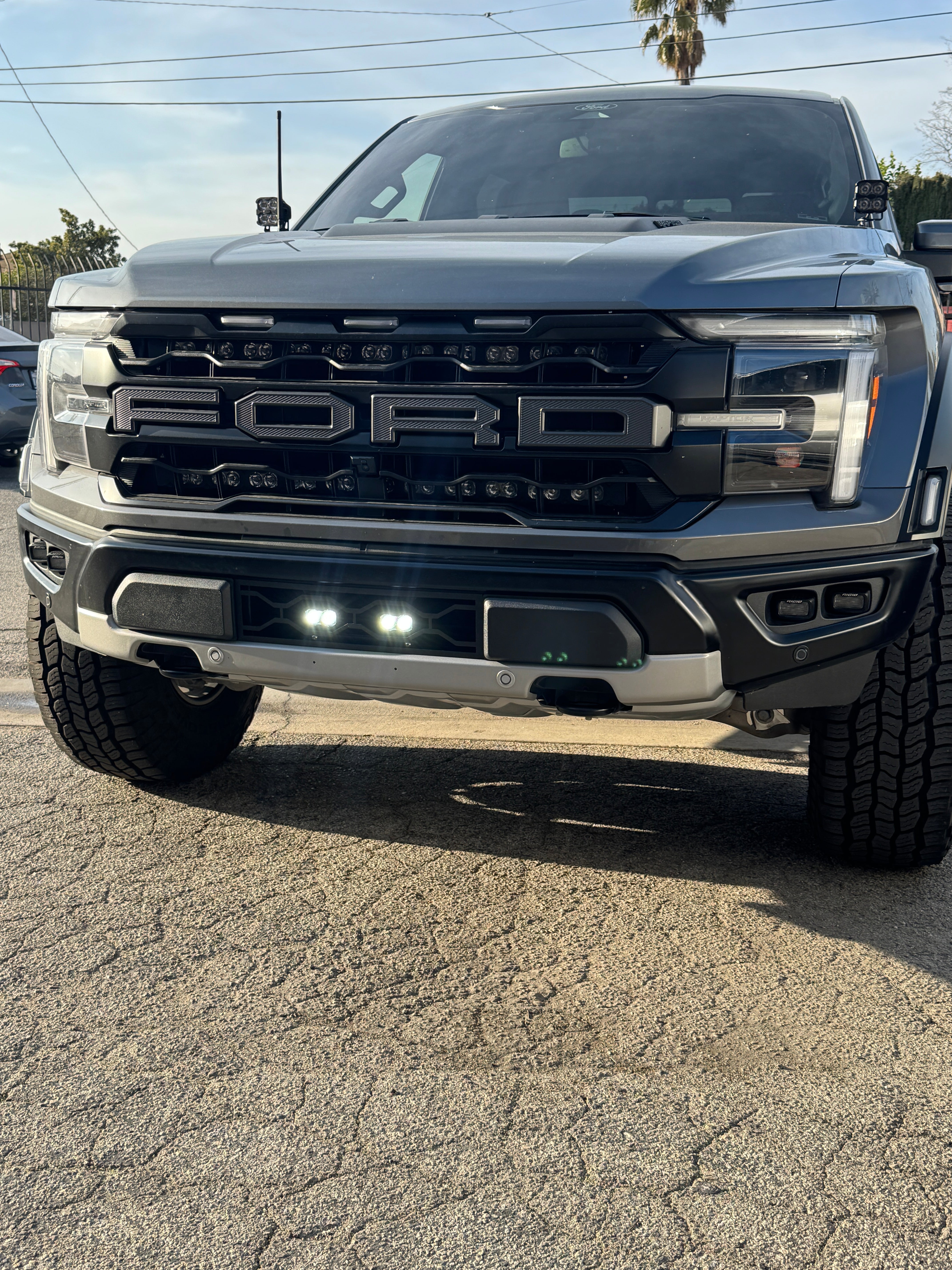 2024+ Ford Raptor Gen 3 Refresh Guard Plate on front of bold Ford truck with illuminated LEDs