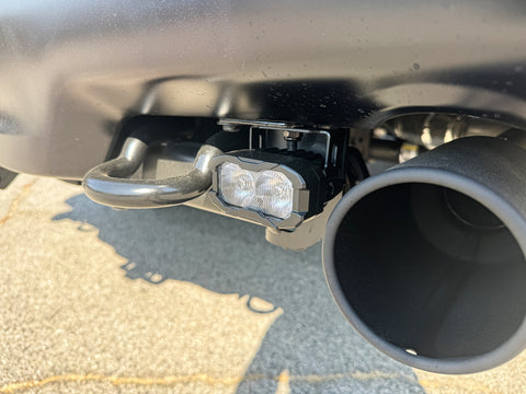 Ford Raptor Gen 3 reverse kit installed on 2024+ Refresh — dual LED reverse lights with bumper hook and exhaust nearby