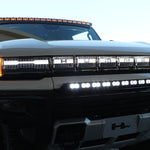 white hummer ev with amber drl roof light bar, white bumper light bar and ditch lights