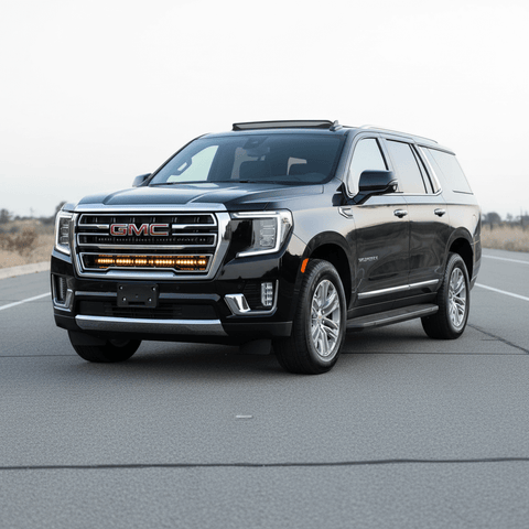 GMC Yukon with a single 40in light bar mounted under the logo on a clear road.