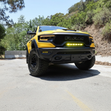Yellow 2019-2024 RAM 1500 TRX with fog light kit running the amber DRL in the front bumper, straight-on front view