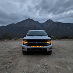 2024+ Ford F150 LightBar with illuminated lights in front of mountains in off-road setting.