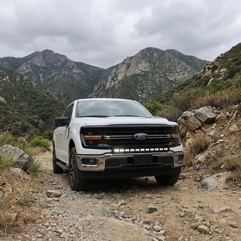 2024+ Ford F150 LightBar mounted on a white Ford F150 in a rugged mountain landscape.