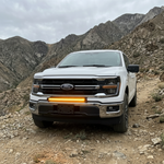 2024+ Ford F150 LightBar installed on a white Ford F150 in a mountainous terrain.