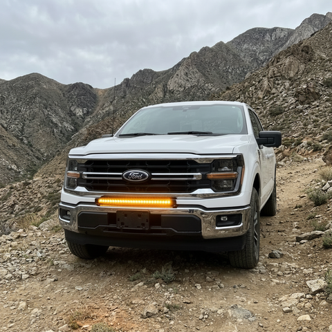 2024+ Ford F150 LightBar installed on a white Ford F150 in a mountainous terrain.