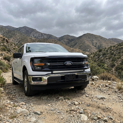 2024+ Ford F150 LightBar installed on a white Ford F150 in a rugged mountainous terrain.