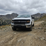 2024+ Ford F150 LightBar installed on a white Ford F150 driving on a rugged off-road trail.