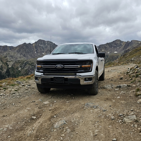 2024+ Ford F150 LightBar installed on a white Ford F150 driving on a rugged off-road trail.