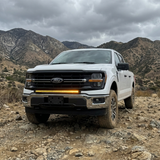 2024+ Ford F150 LightBar mounted on a white Ford F150 in a rugged mountain landscape.